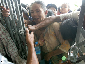 Victims of Cyclone Nargis rush to get first in line to receive donated goods from a local donor at a monastery outside the capital of Yangon, Myanmar on Monday May 19, 2008.