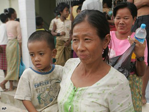 Victims of Cyclone Nargis smile as they receive donated goods from a local donor at a monastery outside the capital of Yangon, Myanmar on Monday May 19, 2008.