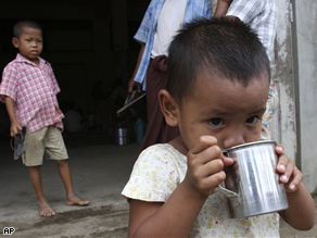 A homeless Burmese boy drinks clean water at a monastery for a temporary shelter on the outskirts of Yangon, Myanmar.