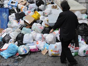 A woman adds to the trash pile.