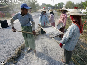 A road construction crew in Myanmar adds new surface to a highway north of Yangoon.