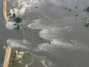 The Mississippi River rushes through a break in Indian Grave Drainage District levee north of Quincy, Ill