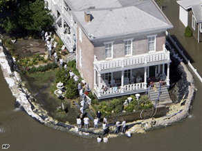 Volunteers work to protect a home from the rising flood waters of the Mississippi River Thursday, June 19 in Clarksville, Mo.
