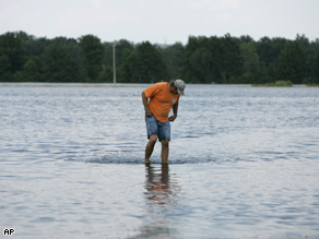 Mark Rowland wades through floodwater near his home, June 19. Levels have risen in Lincoln County since then.