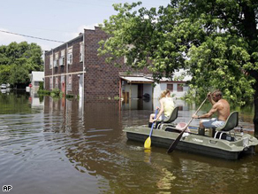 Frankie Davis and her husband paddle a boat through floodwaters back to their house in Foley, Mo., Wenesday.