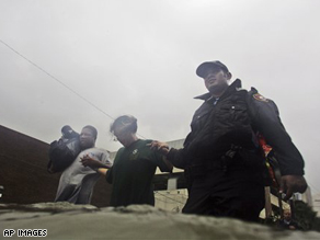 Police officer Hassan Mustafa, Jesse West, and Carl Reynolds wading through the storm surge in Galveston, Texas.