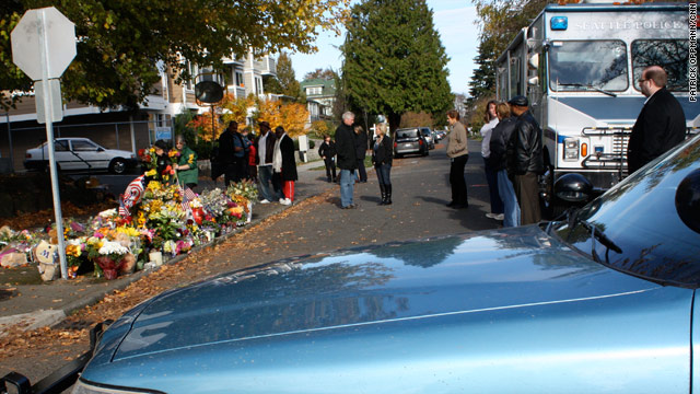Flowers are placed on the street earlier this week where Officer Timothy Brenton was shot and killed.