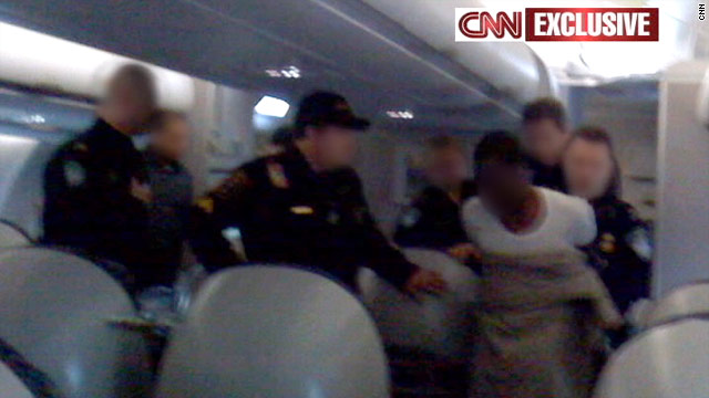 CNN obtained this exclusive photo of the suspect being taken into custody on board the plane.