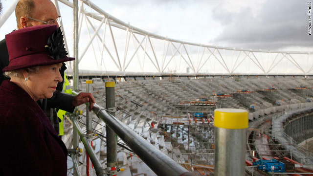 Queen Elizabeth is shown around the site of the London Olympic stadium.