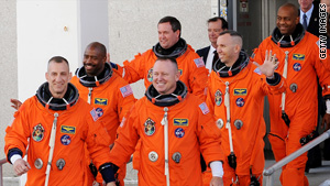 The space shuttle Atlantis crew members walk to the van that will take them to the launch pad Monday.