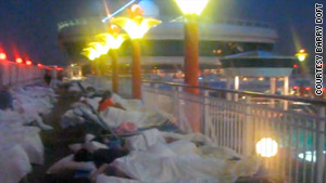 Passengers sleep on the deck of the Norwegian Dawn after a power failure on the ship.