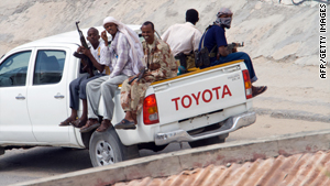 Somalian soldiers pass an African Union Mission in Somalia base in Mogadishu, on November 24, 2009.