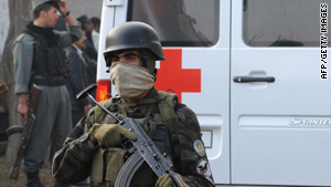 An Afghan police officer guards an ambulance carrying victims of the attack that killed five U.N. personnel.