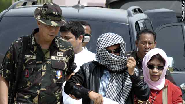 Andal Ampatuan Jr., center, with his wife is escorted by military personnel in Maguindanao on Thursday.