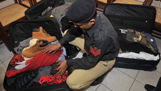 A Pakistani police officer Monday searches a Karachi hotel room  where the five detained Americans reportedly had stayed.