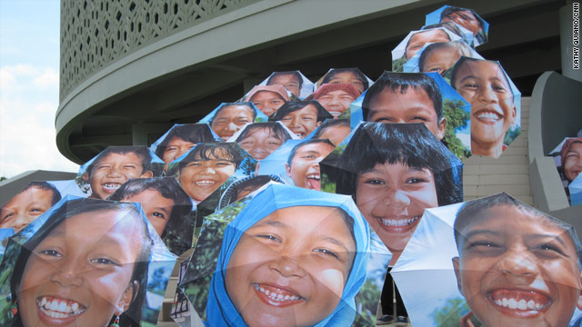Schoolchildren at the tsunami museum in Banda Aceh hold up umbrellas to greet Indonesia's vice president.