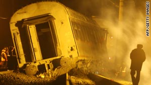 Workers inspect a damaged railway carriage after the derailment on Friday evening.