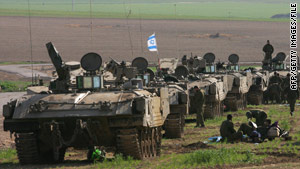 Israeli troops and armored vehicles wait on the Israel-Gaza border in January.