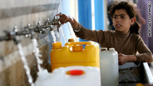 A girl fills water bottles at a United Nations relief camp in Gaza on Tuesday.