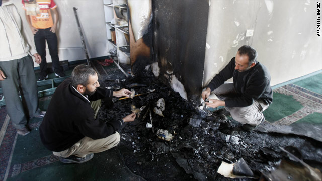 Palestinians inspect damage to a mosque that was set on fire in the West Bank village of Yasuf.