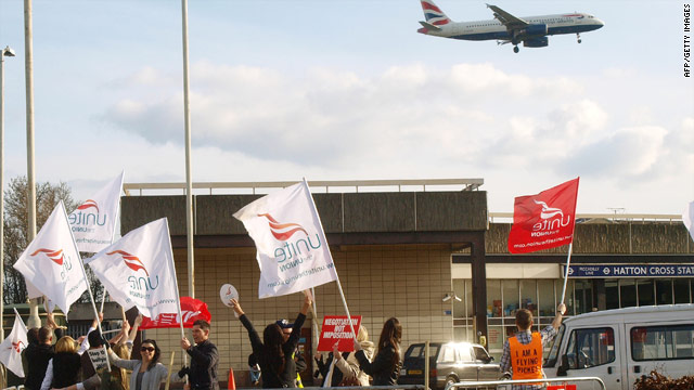 A BA plane approaches Heathrow Airport in London in front of a Unite union picket.