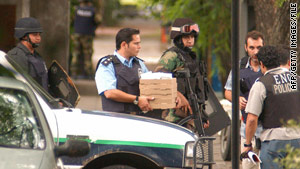 A policeman carries pizza that robbers ordered during the January 2006 bank heist in Acassuso, Argentina.