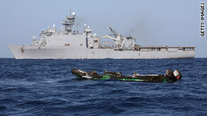 The burned out hull of a suspected pirate skiff drifts near the USS Ashland on April 10, 2010, in the Gulf of Aden.