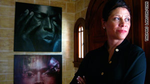 Holley strikes a pose by her front door. The portraits on the left are of musician Miles Davis.