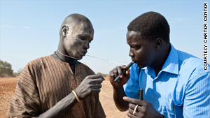 At right, James Madol, a nurse and regional coordinator, instructs how to use a pipe filter properly for drinking water.