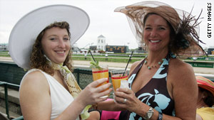Laura Bishop, left, and Catherine Dancy enjoy mint juleps at Churchill Downs in Louisville, Kentucky.