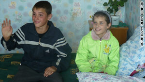 Valery, left, and Marina sit in their orphanage in Russia during their adoption process.