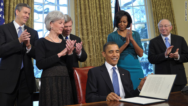 Michelle Obama and Cabinet members look on as President Obama signs a memorandum on childhood obesity.