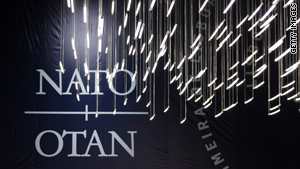 Lights hang in front of a NATO logo during the NATO Summit Friday in Lisbon, Portugal.