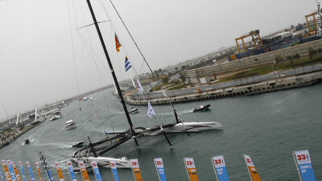 Alinghi's giant catamaran returns to Valencia's harbor after the first day of racing was postponed.