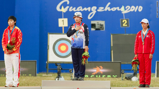 Archery gold medallist Yun Ok-hee from South Korea (center) stands next to bronze medallist North Korea's Kwon Un Sil (right).