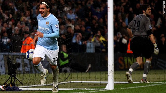 Carlos Tevez celebrates his third goal for Manchester City against Wigan.