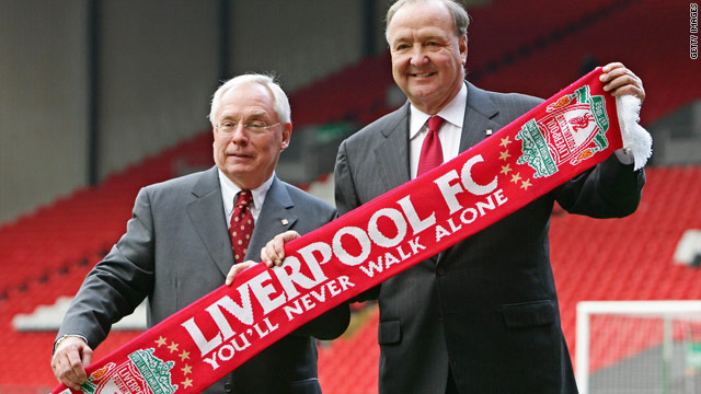 George Gillett (L) and Tom Hicks pose with a team scarf at the Anfield stadium in Liverpool.