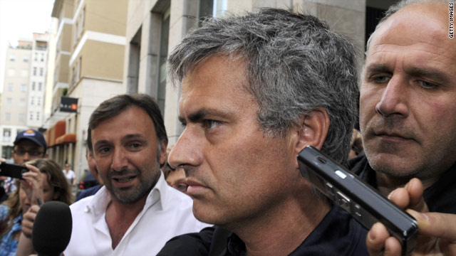 Jose Mourinho is swamped by the media as he leaves a bar in central Milan.
