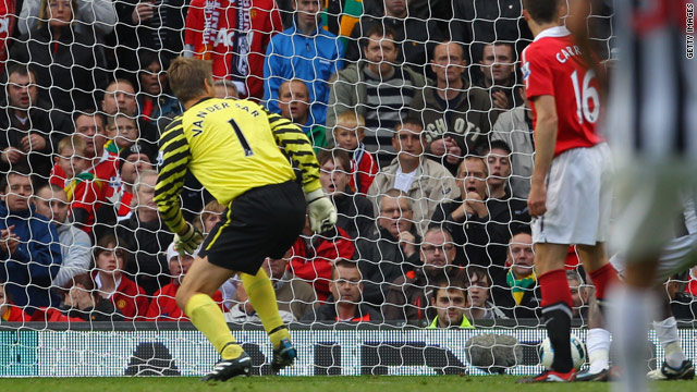 Manchester United's goalkeeper Edwin Van Der Sar can only watch as the ball goes into the net after he fumbled a cross.