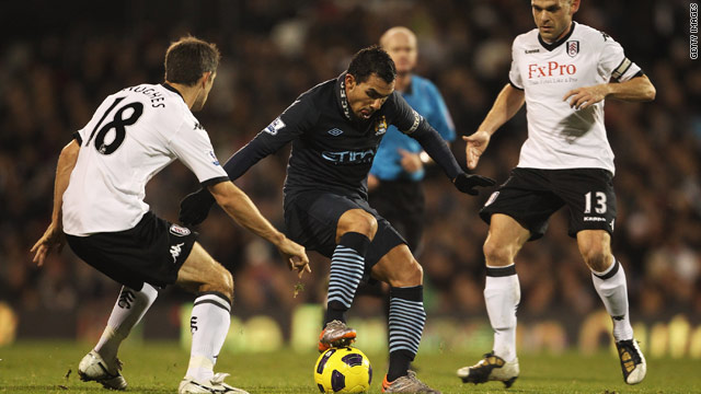Manchester City's Carlos Tevez evades the attentions of Fulham's Danny Murphy and Aaron Hughes at Craven Cottage.