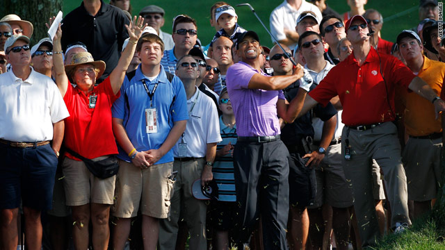 Tiger Woods watches his shot from the rough on the 10th hole in front of a gallery of fans during the second round.