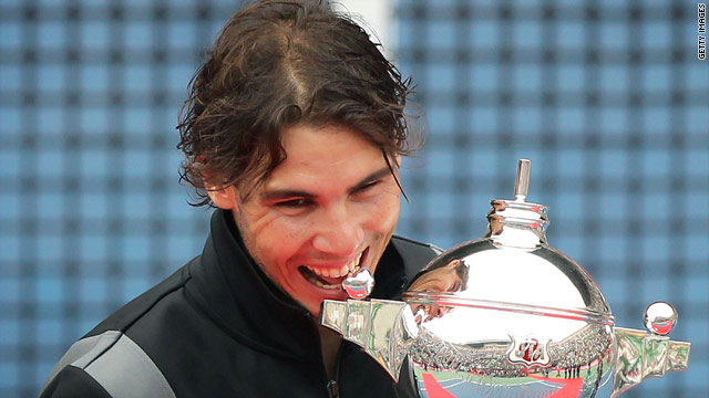 Rafael Nadal takes his traditional bite out of the trophy after winning the Japan Open title. 
