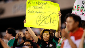 A fan hoists a protest sign during an international baseball tournament game Friday in New Jersey.