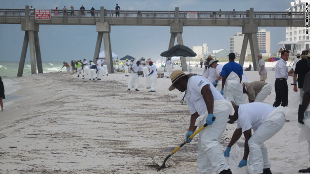 Workers clean a stretch of beach affected by oil in Pensacola Beach, Florida, on Wednesday.
