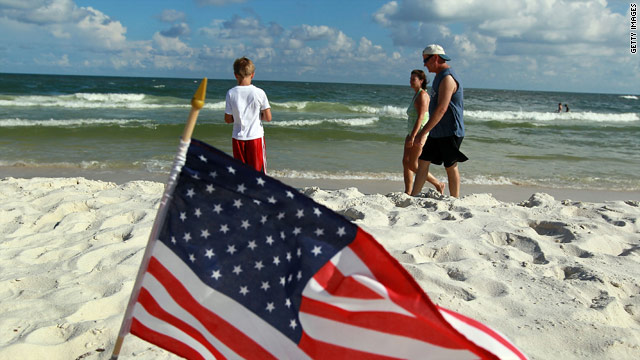 Visitors walk on the beach in Gulf Shores, Alabama, on July Fourth.