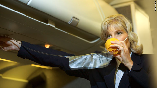 A flight attendant demonstrates safety procedures before takeoff. The job was once considered glamorous.