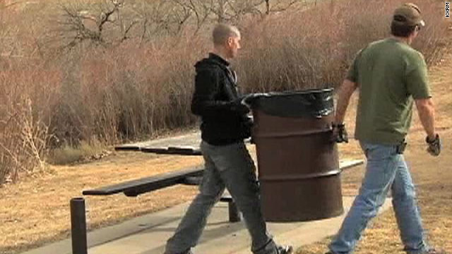 City workers remove trash bins in one of Colorado Springs' parks, an effort to close a nearly $30 million budget gap.