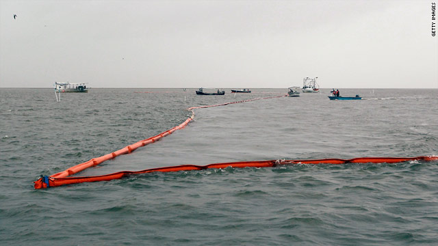 Workers deploy a boom in Drum Bay, Louisiana, on Sunday in an effort to control the oil spill in the Gulf of Mexico.