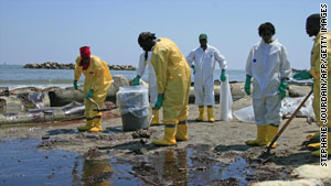 A BP cleanup crew shovels oil from a beach in Port Fourchon, Louisiana.