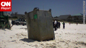 A larger container with BP markings washes ashore Saturday on a part of a beach in Panama City, Florida.